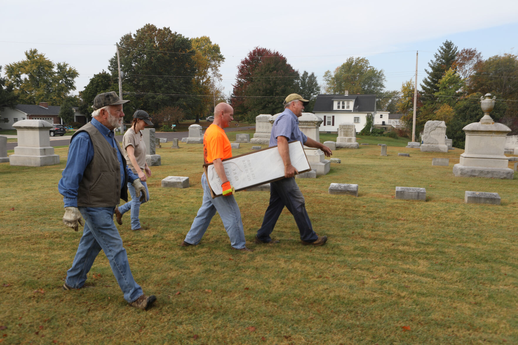 Volunteers transport a headstone